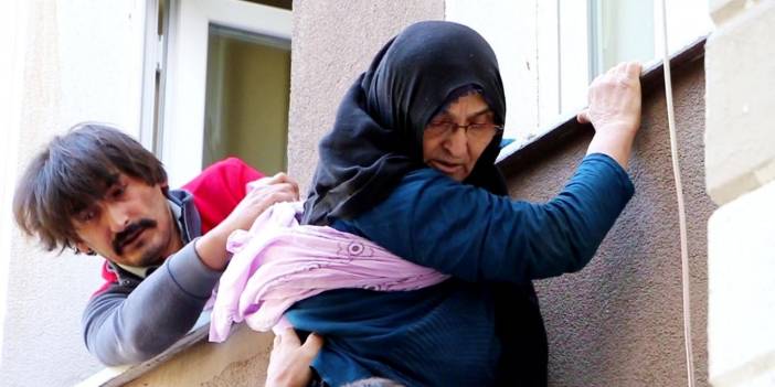 Pencereden atlamak isteyen annesini son anda yakaladığı anlar kamerada